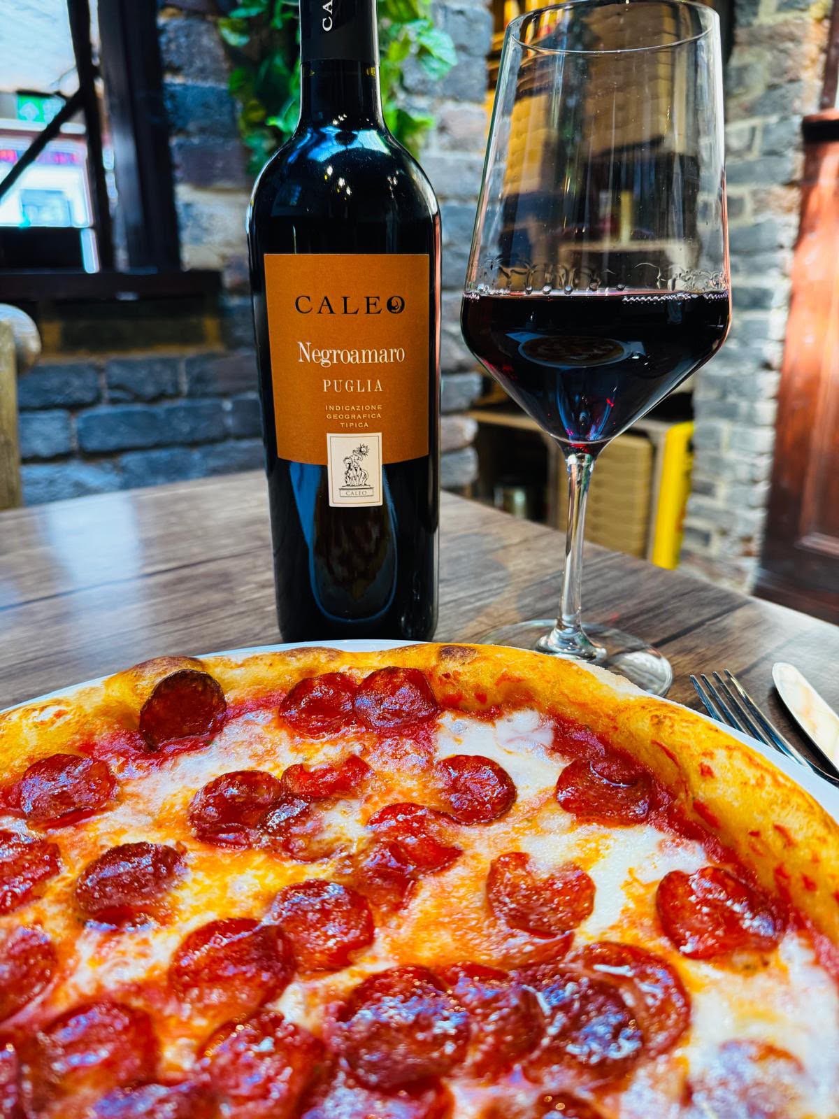 Pepperoni pizza with a glass of Caleo Negroamaro red wine