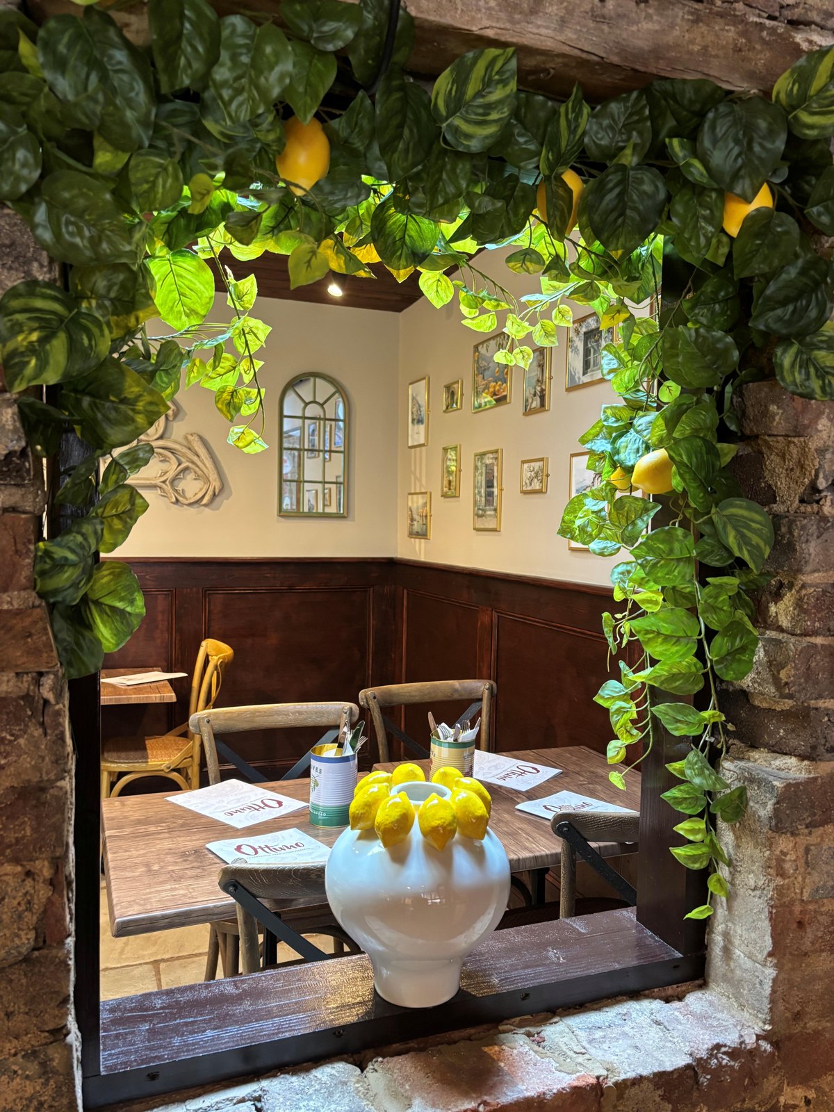 A set dining table seen through the lemon and vine archway